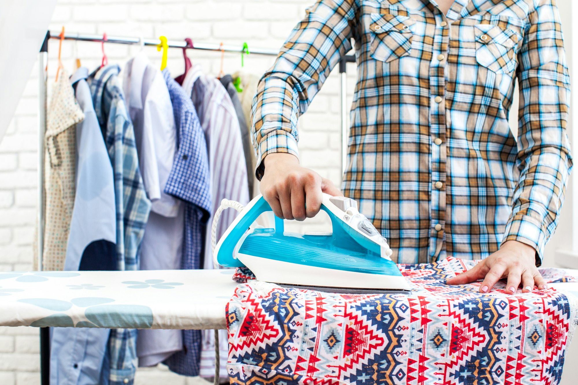 Closeup of woman ironing clothes on ironing board